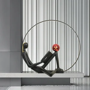 Modern black reader statue floor lamp with glossy red sphere on marble console table, minimalist living room setting
