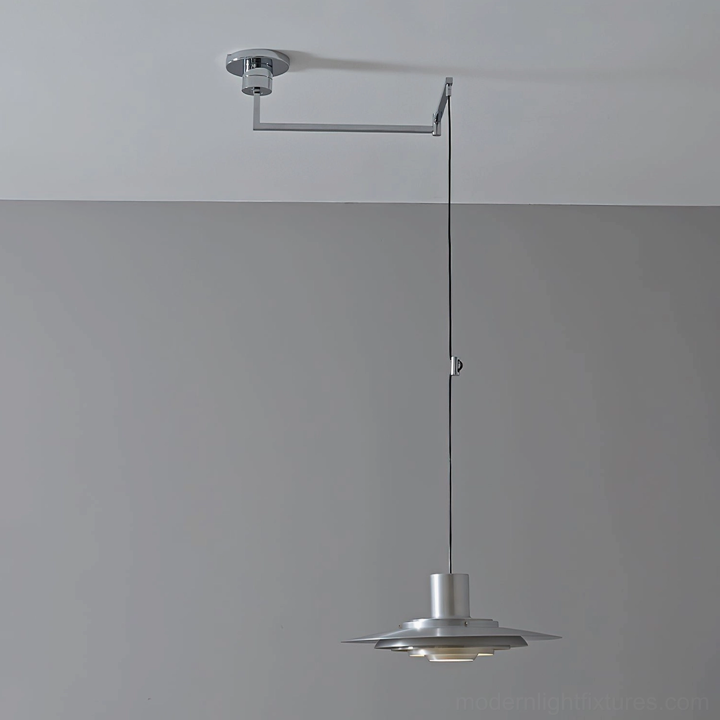 Swing arm pendant light with metallic finish in contemporary interior setting, demonstrating design compatibility and aesthetic integration