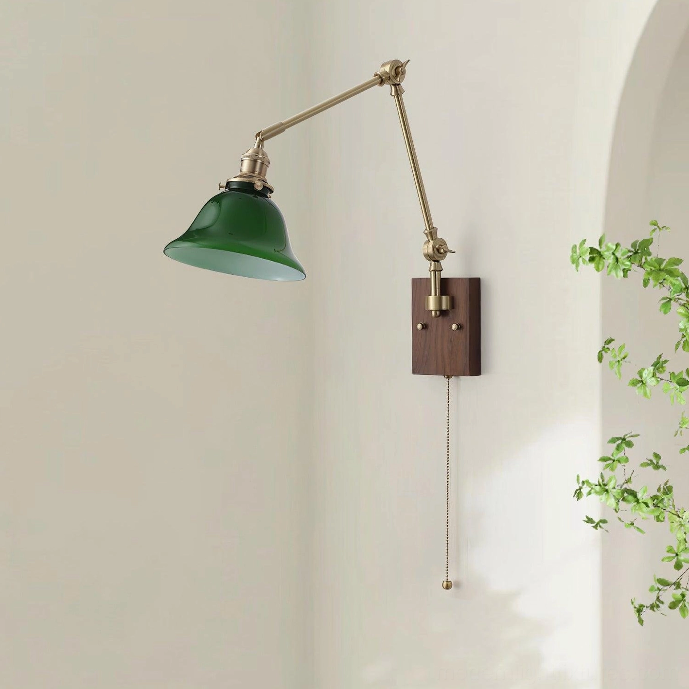 Contemporary swing arm wall lamp featuring green glass shade, smooth brass articulation, and dark wood mount for home office and reading areas
