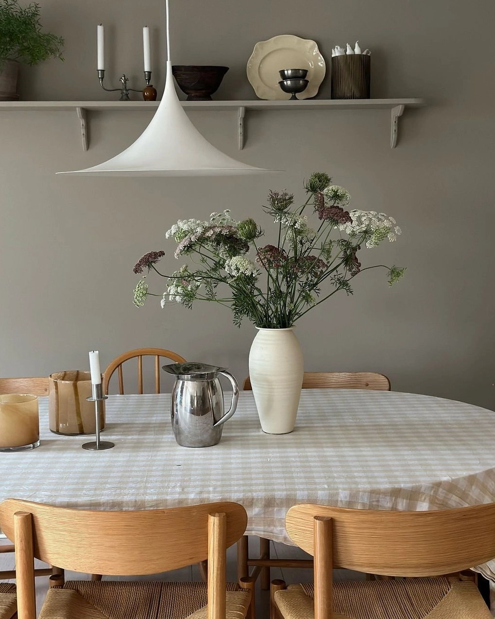 White trumpet swing arm pendant light in contemporary dining room with checkered tablecloth
