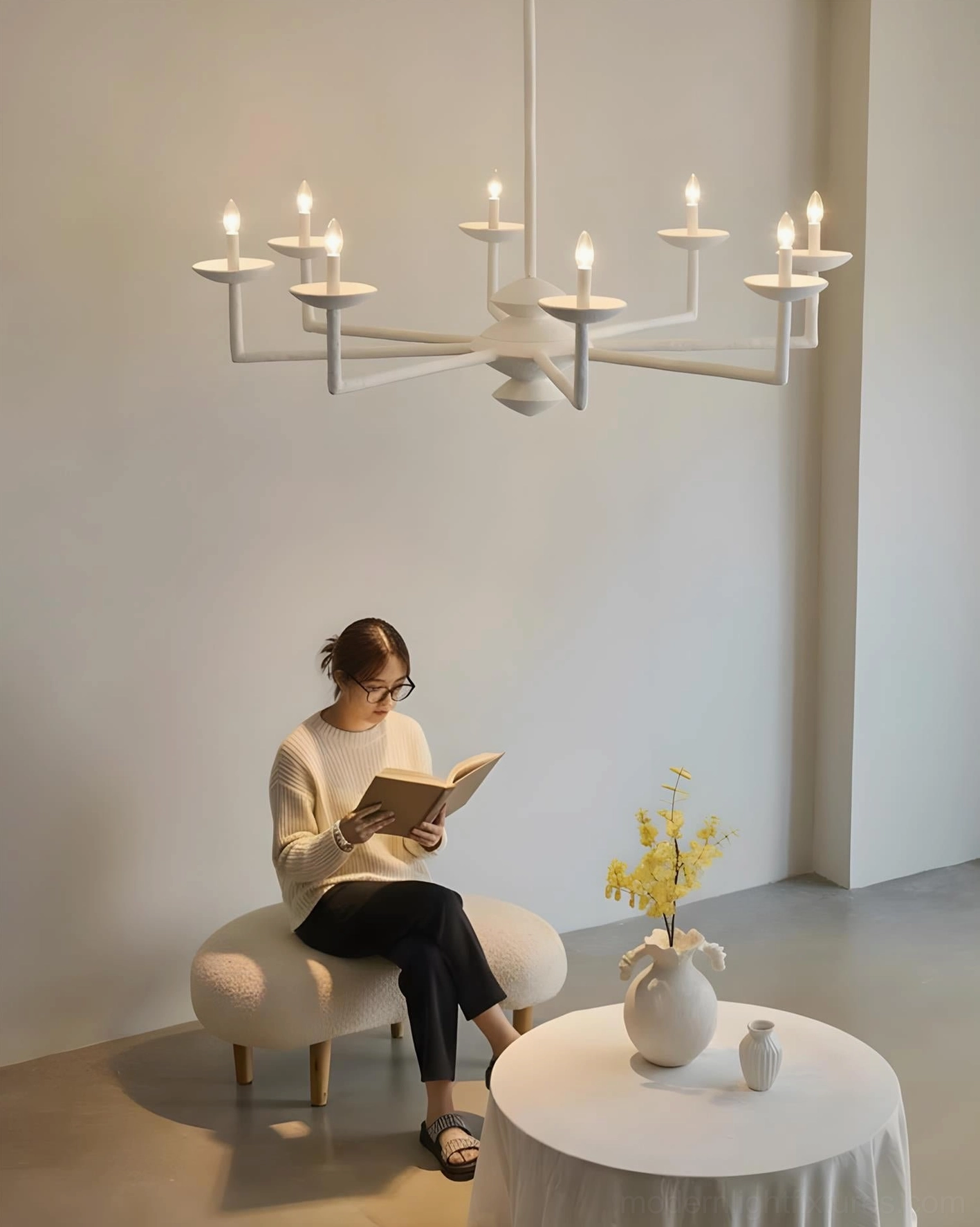 Sculptural vine chandelier with multiple arms in minimalist cafe space, contemporary lighting design