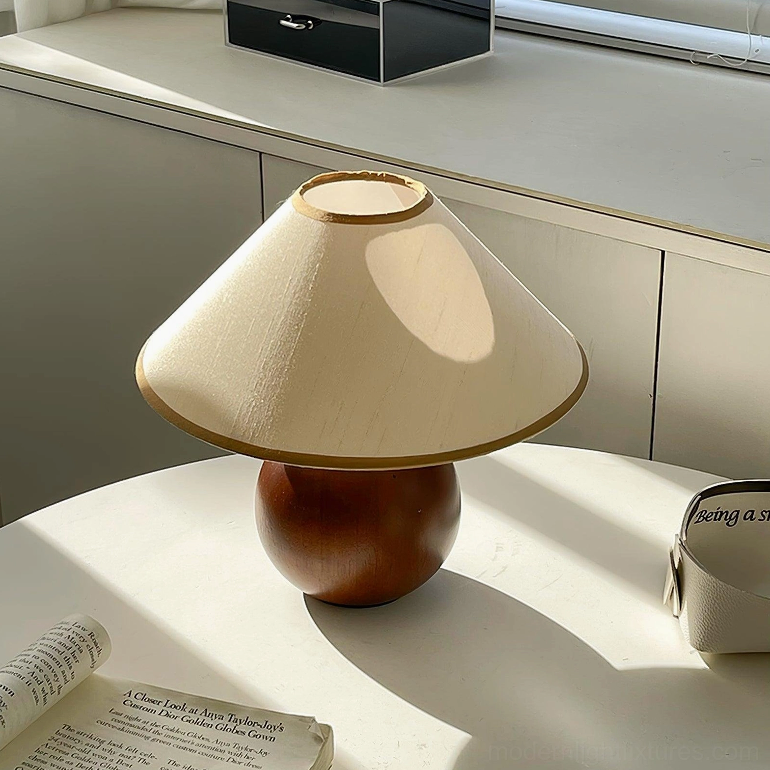 Contemporary table lamp with walnut base on dining table, styled with flowers and vintage accessories