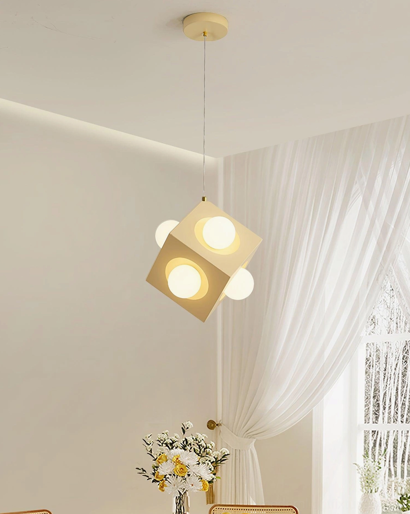 Minimalist cubic pendant light in cozy living room setting with sheer curtains and contemporary decor