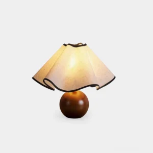 Cora mid-century wood table lamp with curved white fabric shade and spherical walnut wood base, studio view on white background