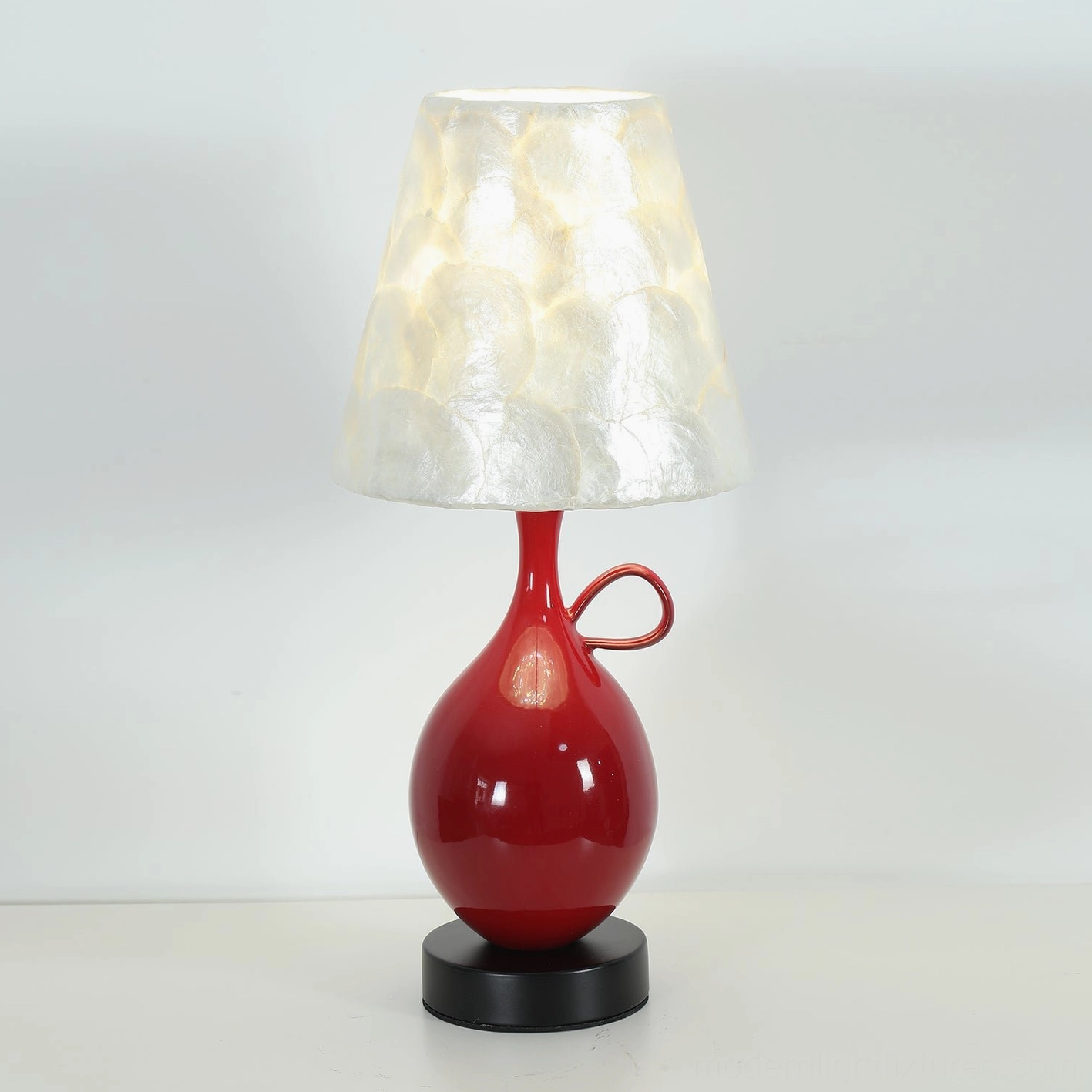 Coravie capiz seashell shade detail showing natural mother-of-pearl tiles and warm light diffusion through translucent shell material
