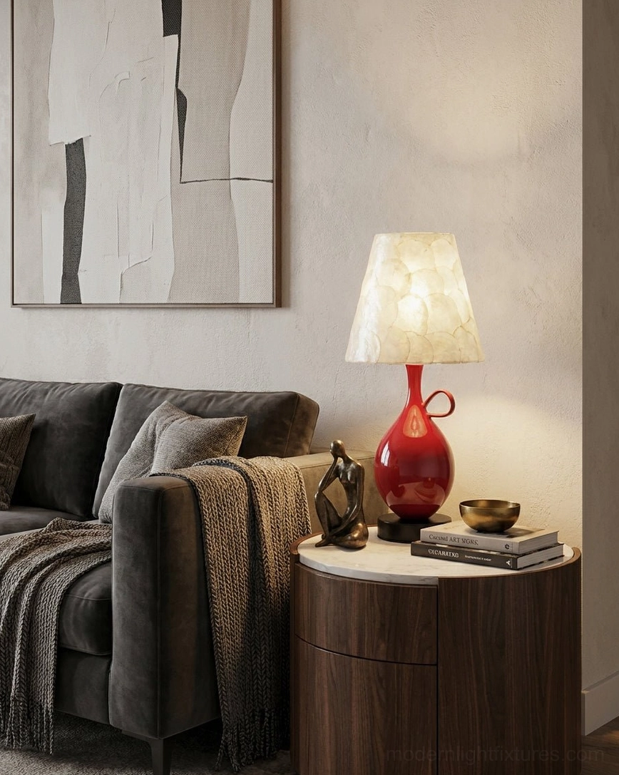 Coravie table lamp on round wooden side table beside dark grey sofa with throw blanket in contemporary cozy living room