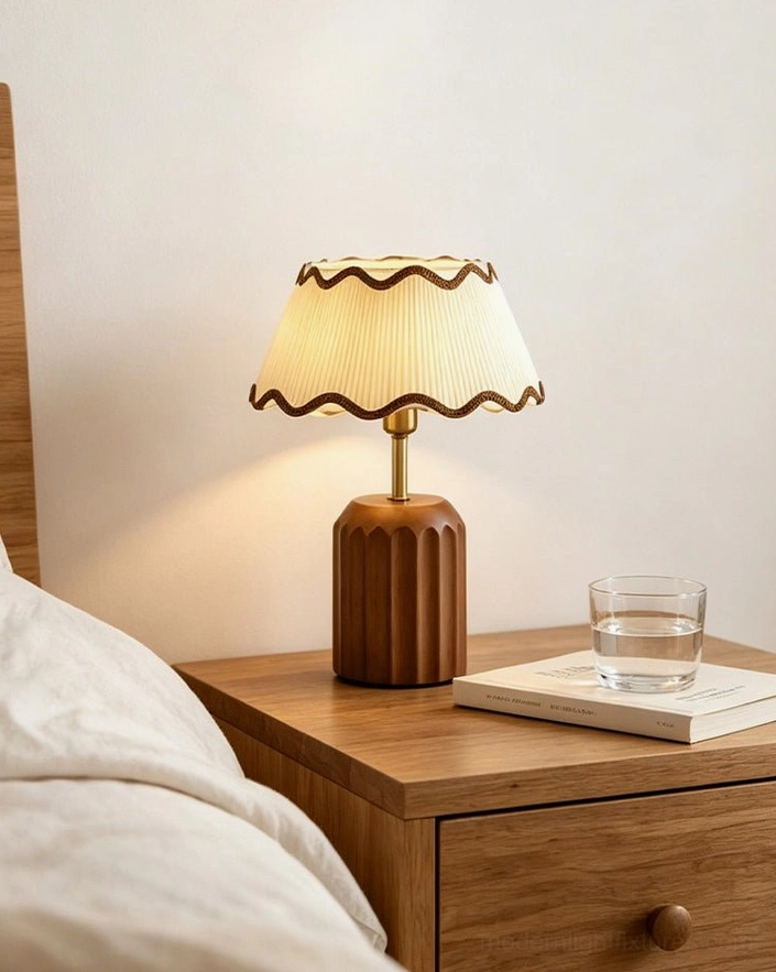 Cordelia bedside table lamp with scalloped pleated shade on bedroom nightstand, fluted brown base with soft warm white LED glow