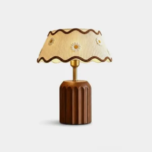 Cordelia cottage table lamp with pleated cream fabric shade and daisy appliqués, studio front view against white background