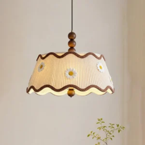 Plain pleated Cordelia fabric pendant light in off-white, close-up overhead view with warm minimalist wall background