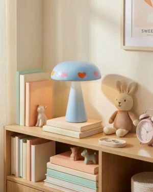 Cordless mushroom lamp displayed on stacked books in home bookshelf setting with warm ambient lighting and decorative accessories