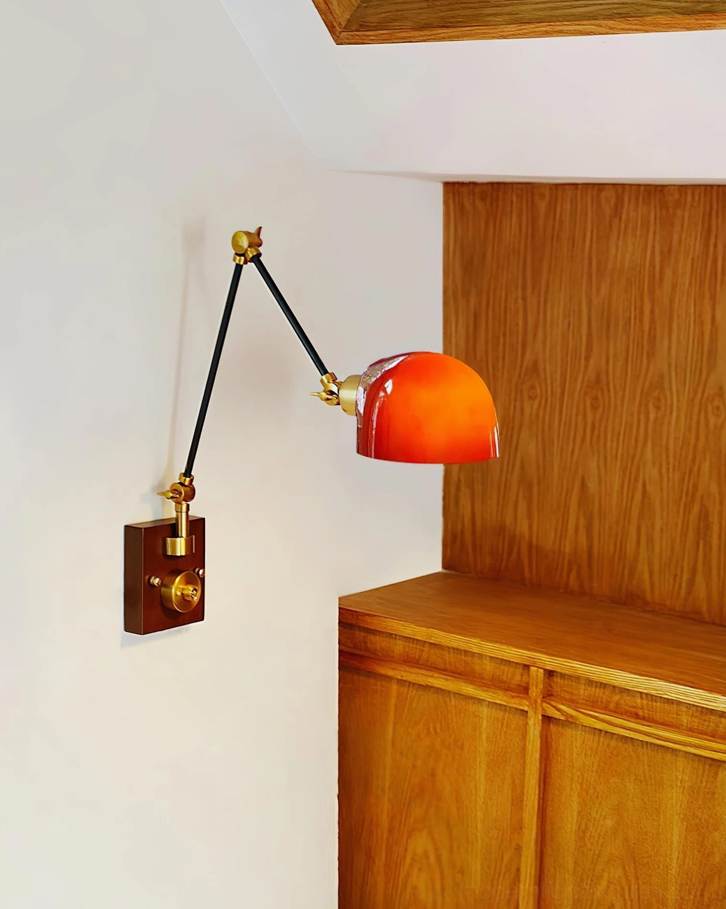 Cordova wall sconce mounted on wooden cabinet, showing red dome shade and side articulation