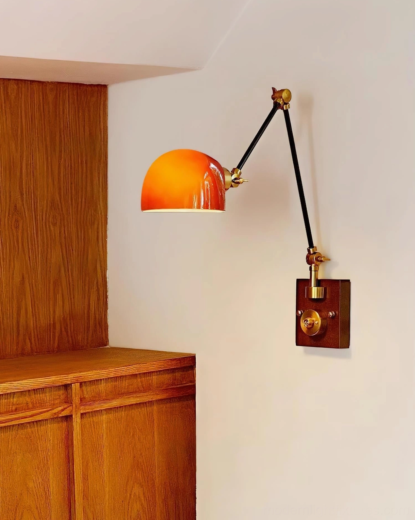 Cordova front-side view wall lamp with reddish-orange dome on wooden cabinet corner