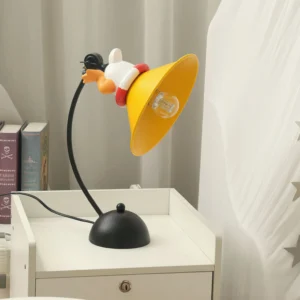 Corgi table lamp positioned on white bedside nightstand with stacked books and sheer curtains, creating cozy bedroom ambiance with modern decorative lighting