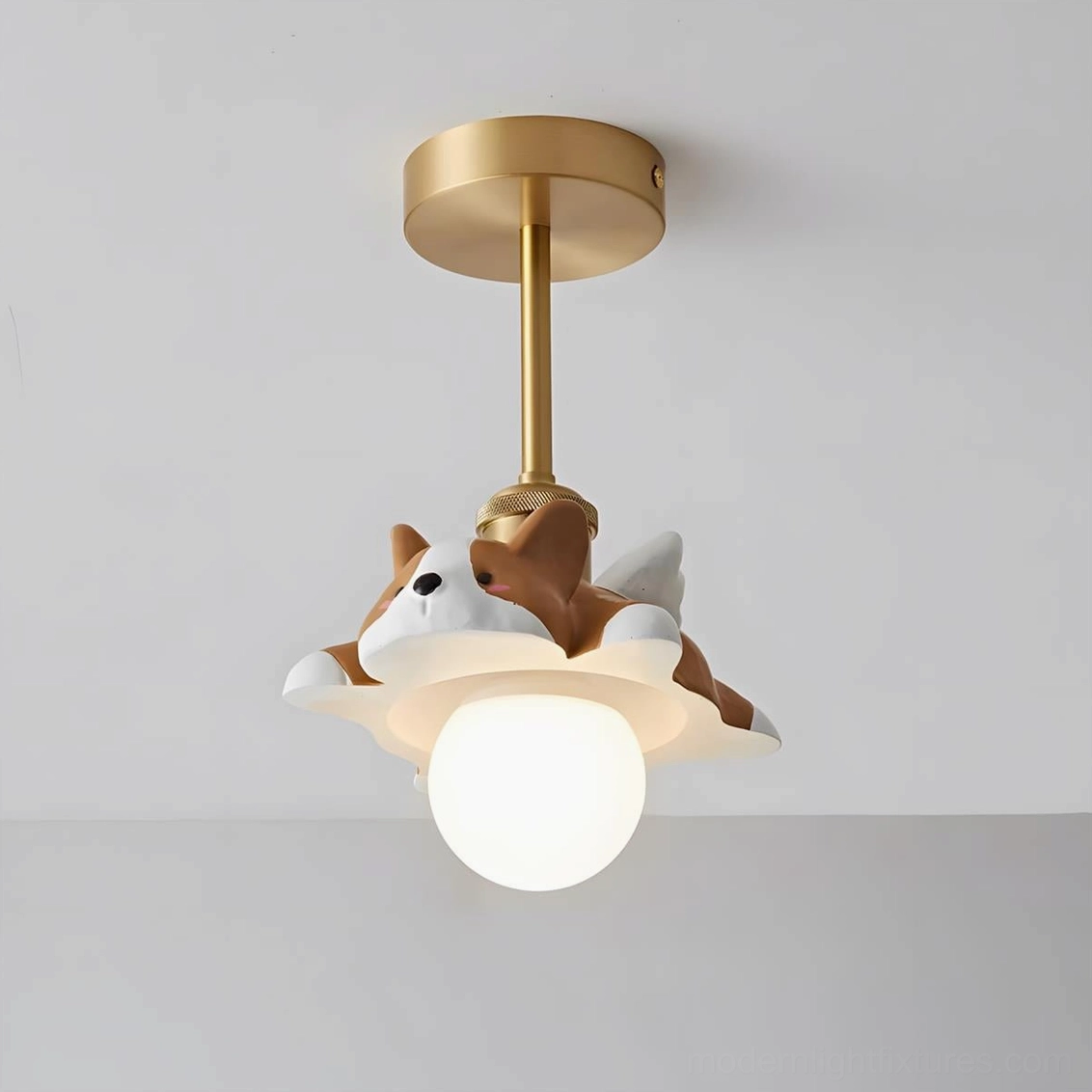 Corgi ceiling light fixture with brass metal wings and brown-white resin puppy on frosted glass orb, close-up studio view