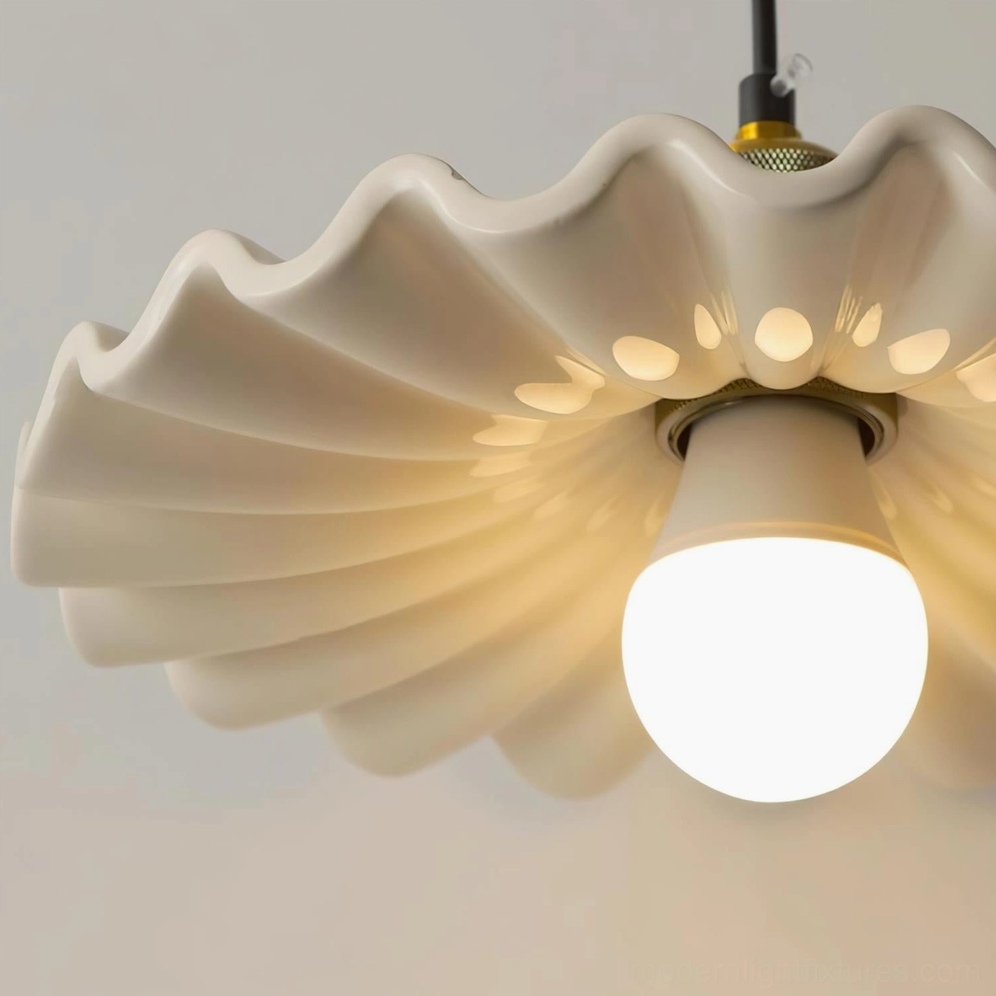 Corolla pendant lamp bottom close-up showing matte off-white ceramic with perforated ventilation holes