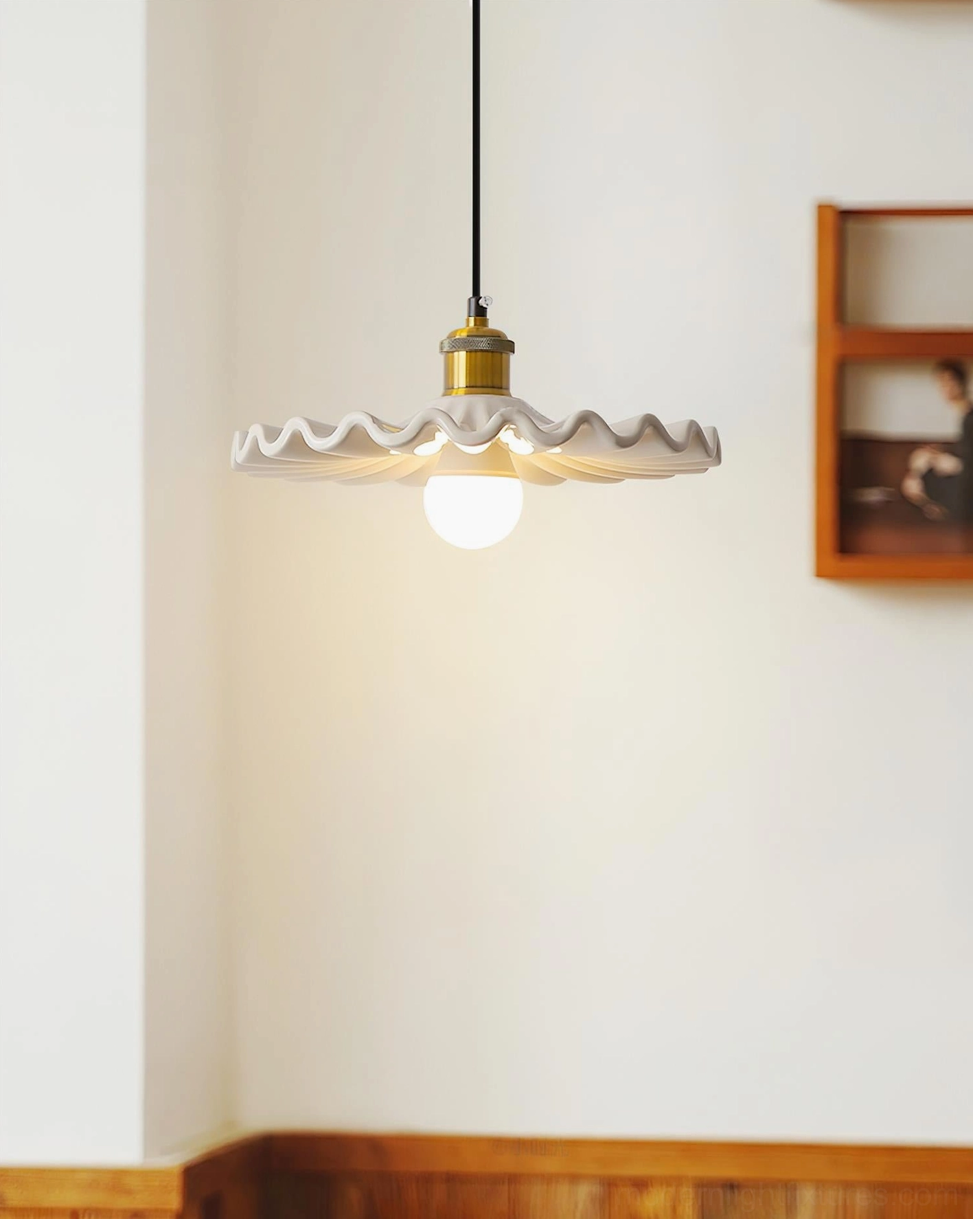 Corolla pendant lamp in minimalist entryway with wooden trim and warm brass fixture, side view