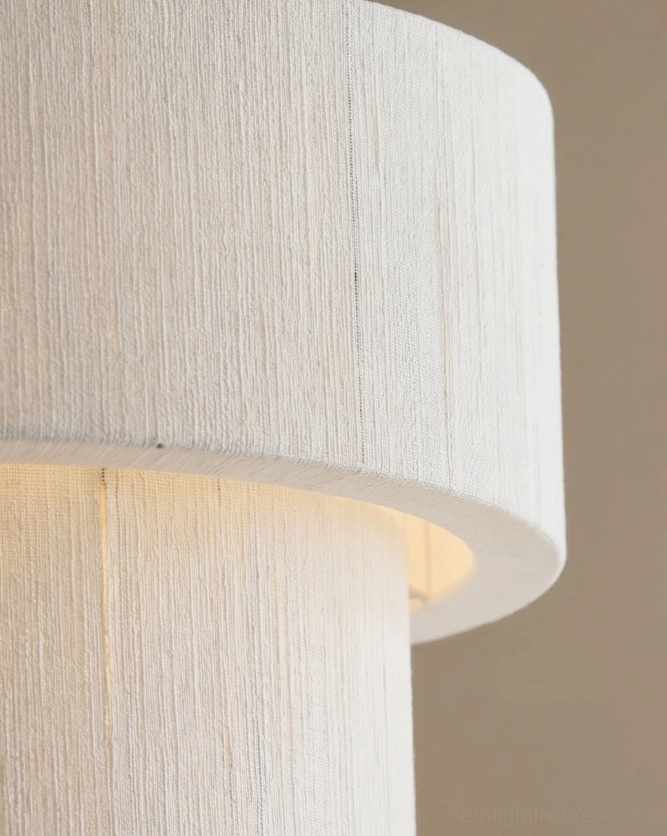 Natural woven linen textile close-up of cotton-thread drum shade showing fine weave texture, warm ambient light diffusion detail