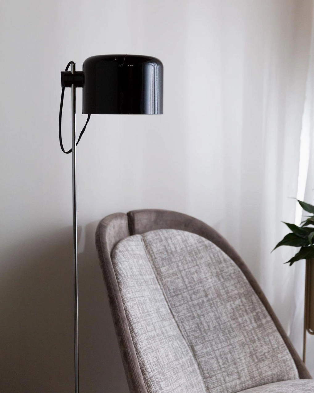 Contemporary adjustable floor lamp with chrome finish and black head in modern minimalist interior