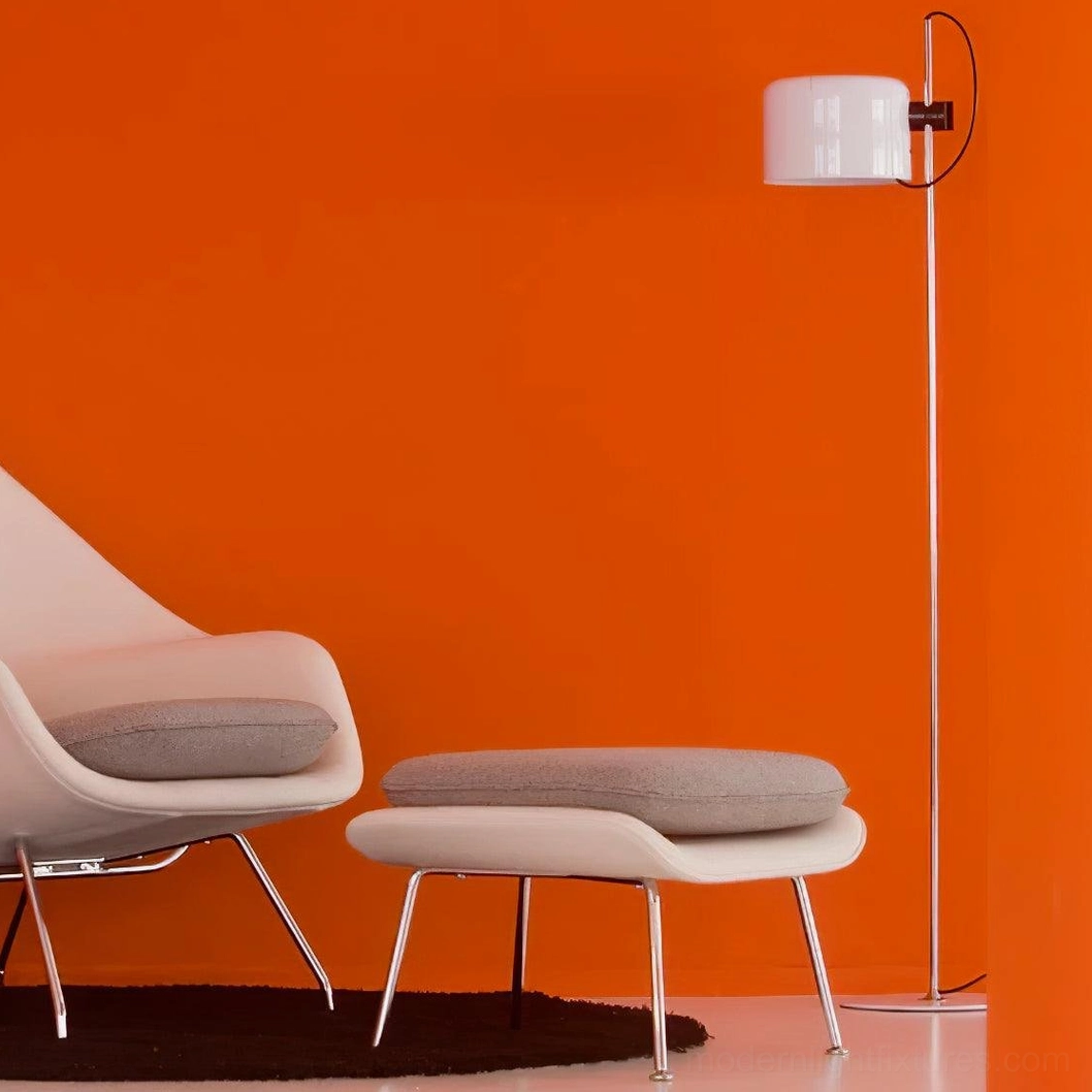 Frosted white shade floor lamp with polished silver metal pole in living room with orange accent wall