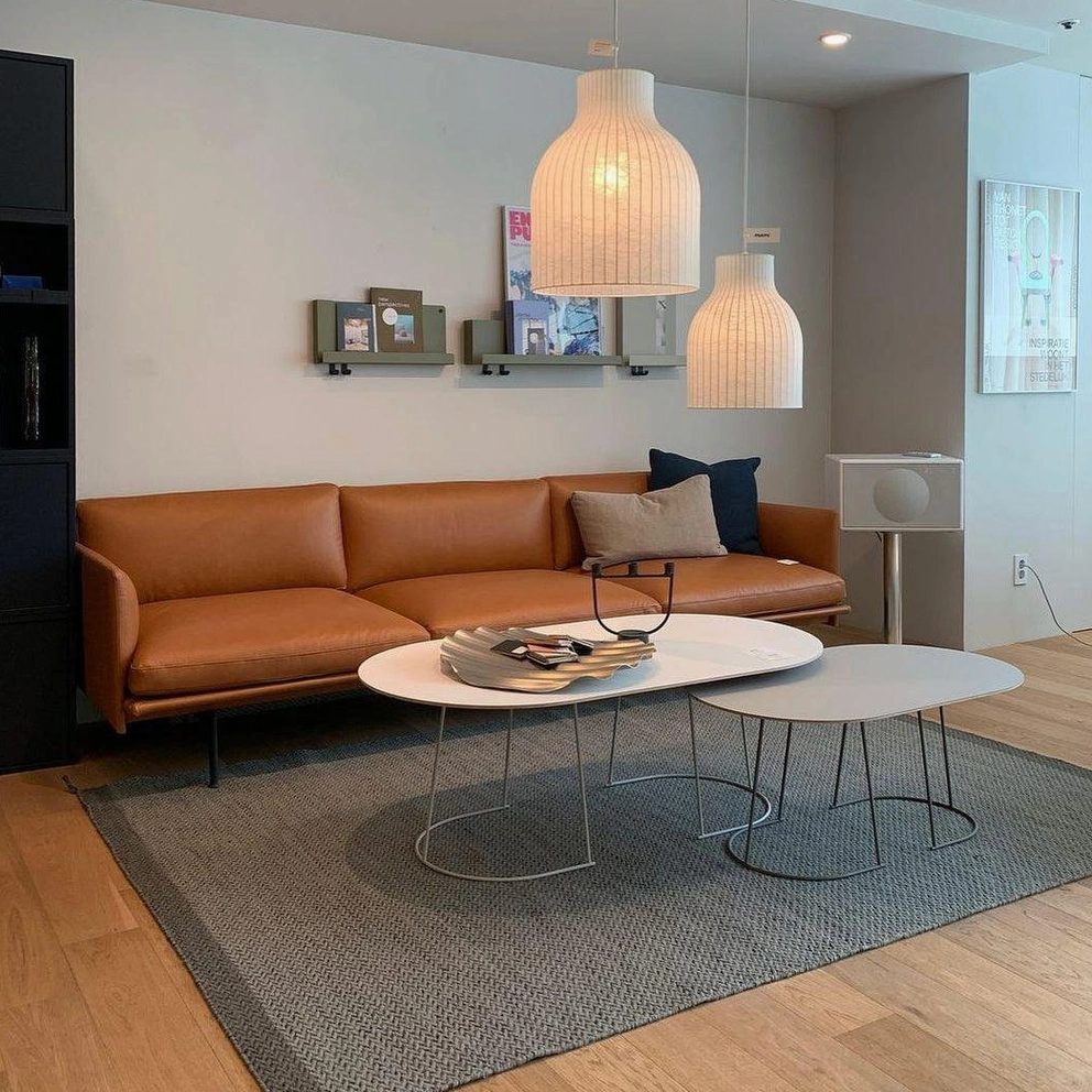 Warm beige ribbed fabric pendant lamps in modern minimalist living room with brown leather sofa