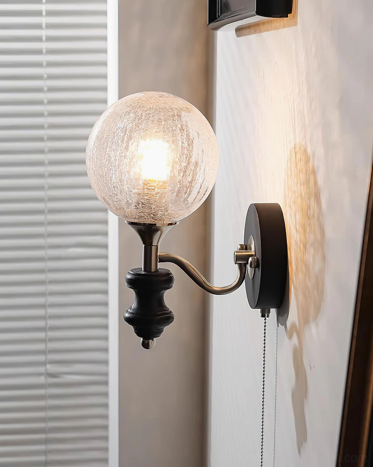 Glowing cracked glass sphere wall sconce in corner accent setting with warm lighting