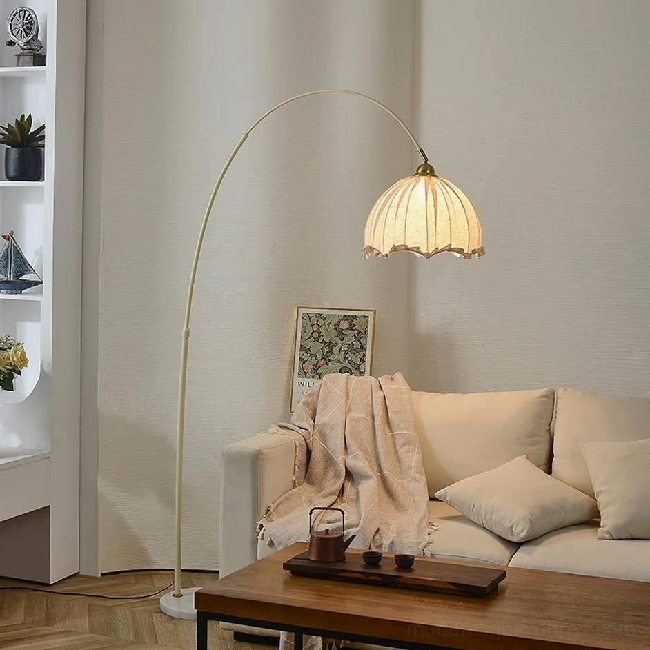 Contemporary arc floor lamp with cream metal pole and beige fabric shade in modern living room