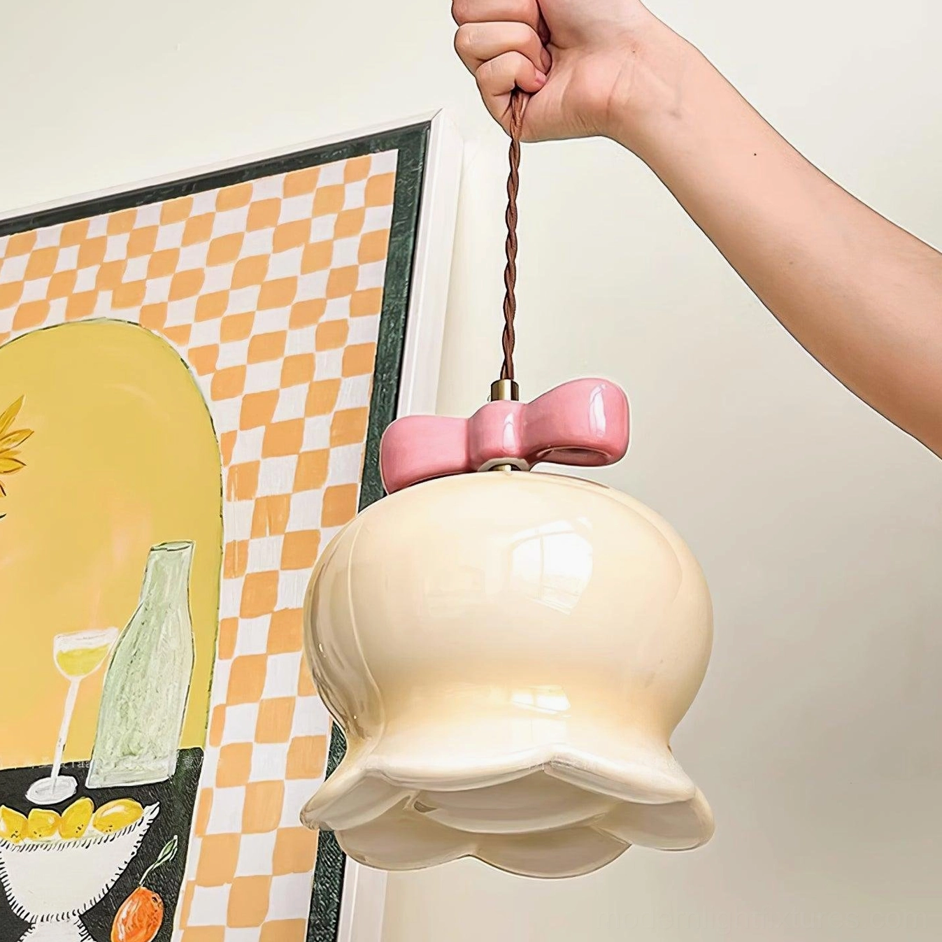 Cream ceramic pendant lamp with glowing shade against ins-style wall art background