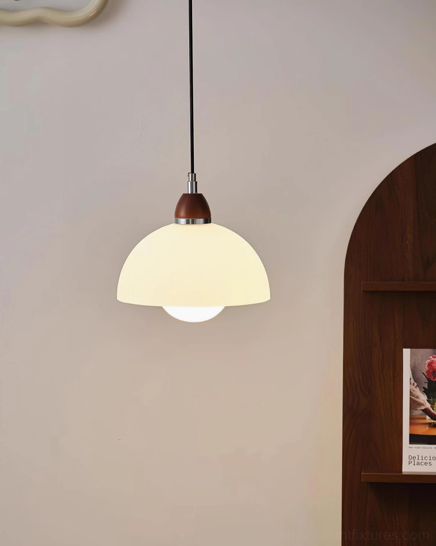 Cream domed pendant lamp, minimalist design with warm matte shade and wooden top cap against modern wall