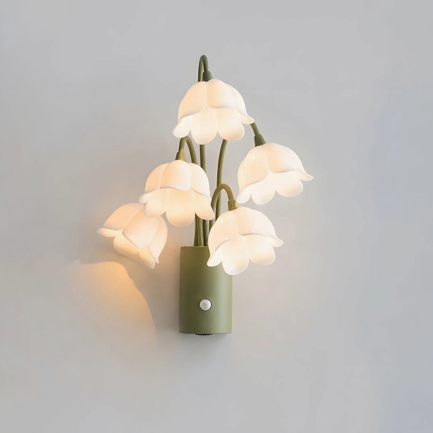 Cream lily-of-the-valley wireless wall sconce with five frosted bell-flower shades on green metal stems, studio gray background