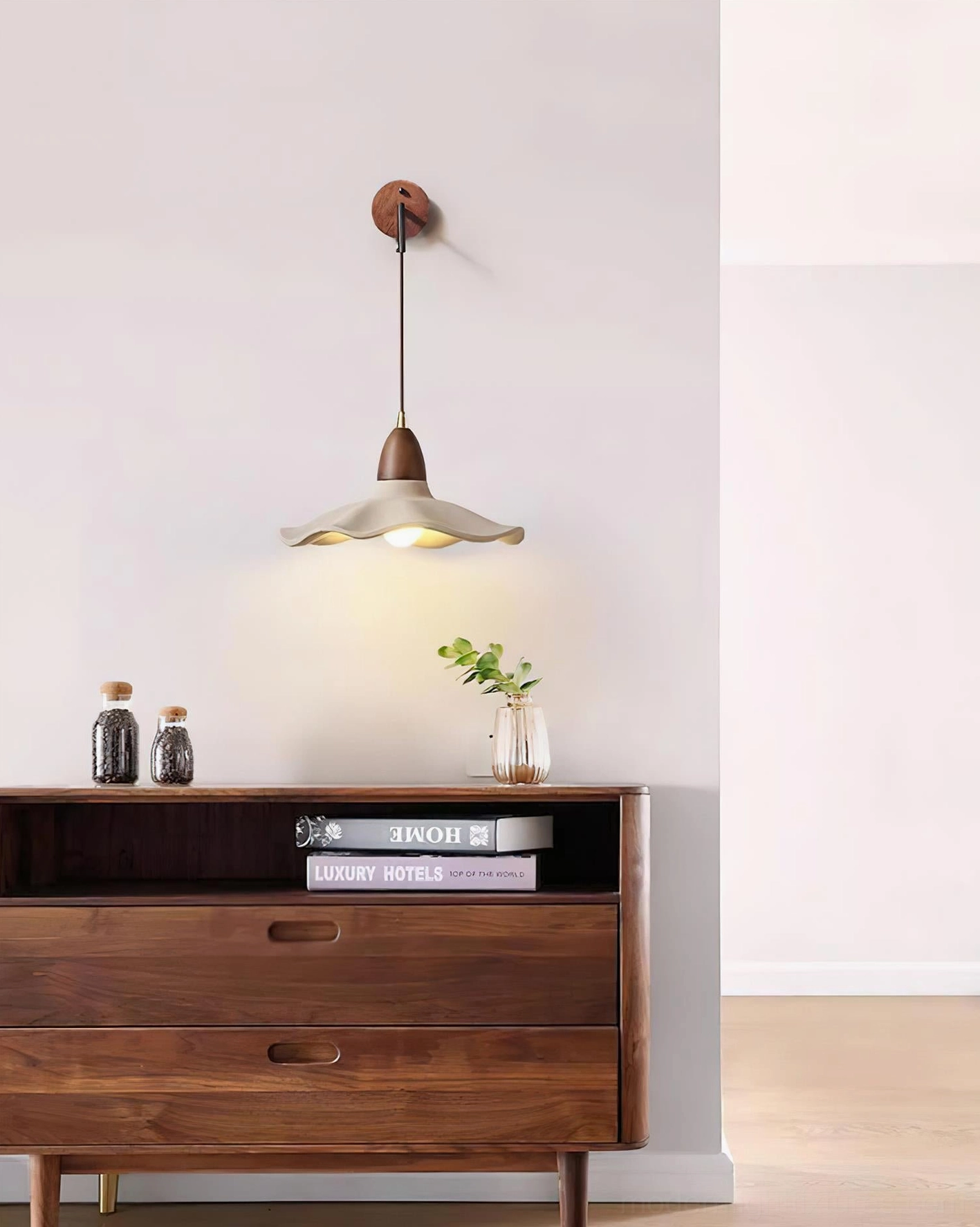 Minimalist bedside wall lamp providing soft reading light in modern bedroom with minimalist wooden dresser