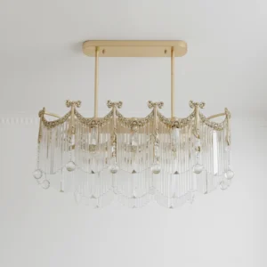 Crystal Cascade Chandelier with scalloped frame design, hanging crystal orbs, and polished gold trim on off-white wall background