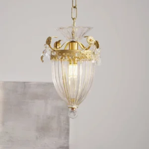 Illuminated crystal pendant chandelier displaying warm brass hardware and faceted glass light diffusion