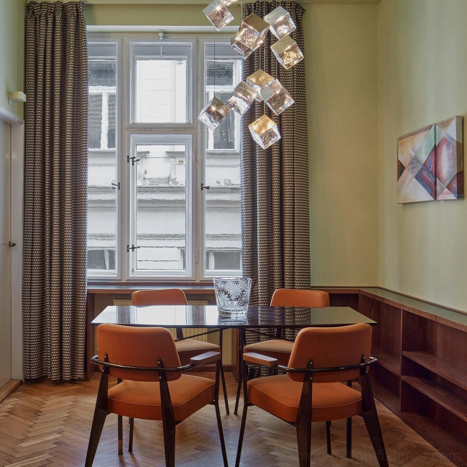 Large geometric glass cube chandelier suspended over dining table luxury setting