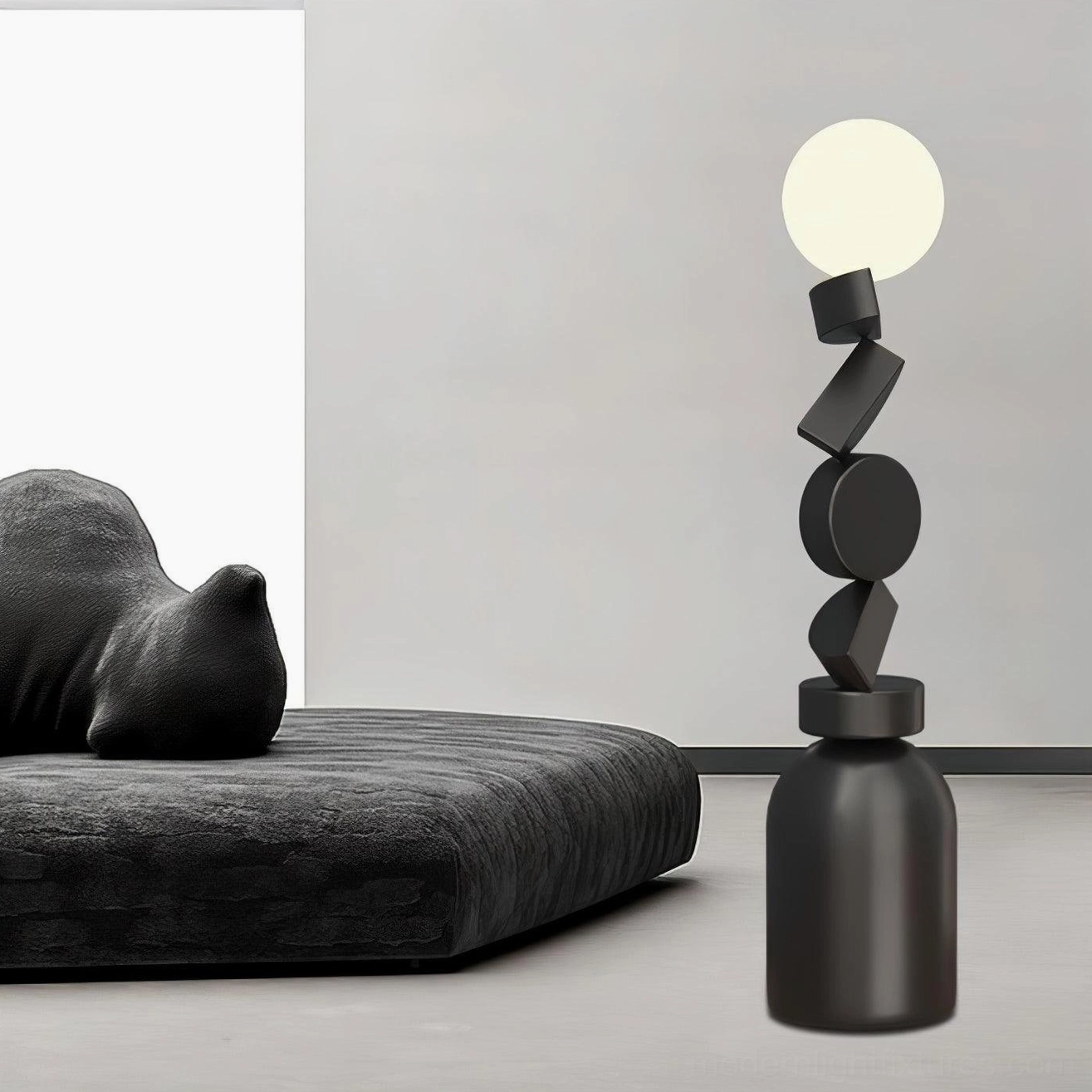 Cubu geometric floor lamp in lounge with dark daybed, three-quarter side view, matte black