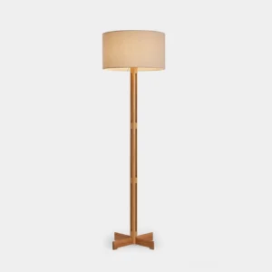Culver minimalist wood floor lamp with perforated pole and X-shaped base, featuring linen drum shade on white studio background