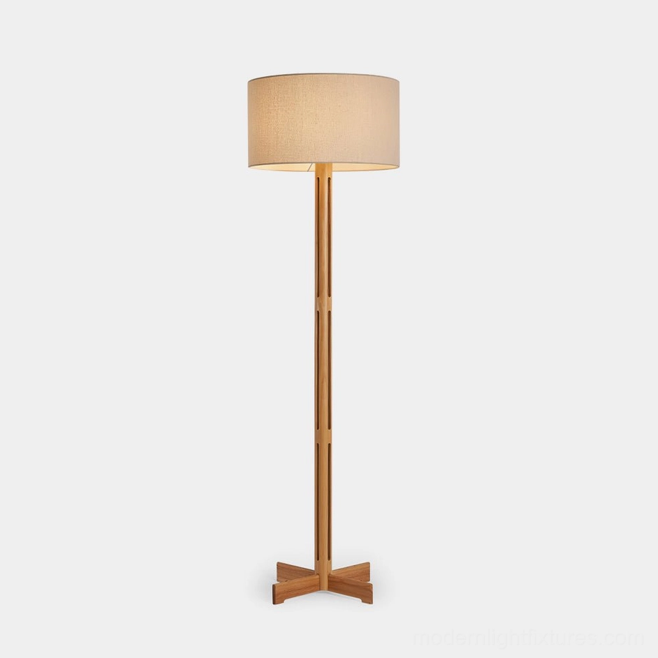 Culver minimalist wood floor lamp with perforated pole and X-shaped base, featuring linen drum shade on white studio background