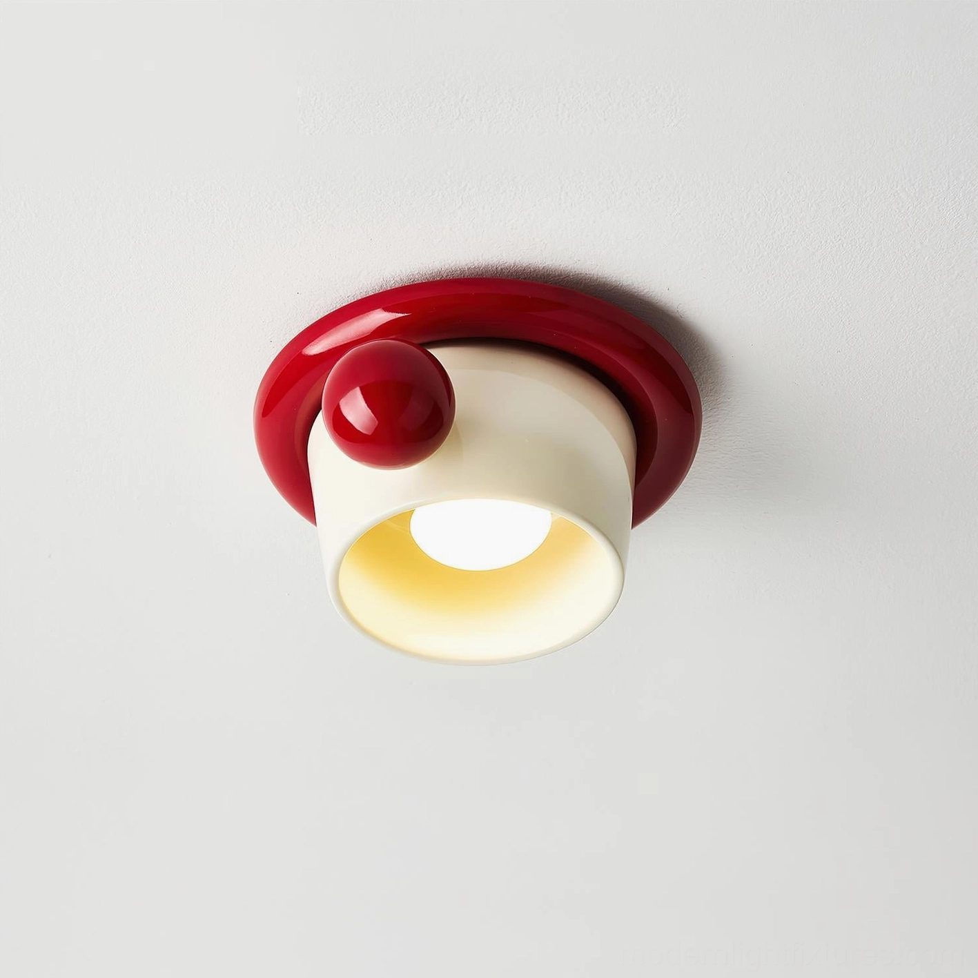 Red teacup-inspired ceiling light fixture studio front close-up with spherical accent