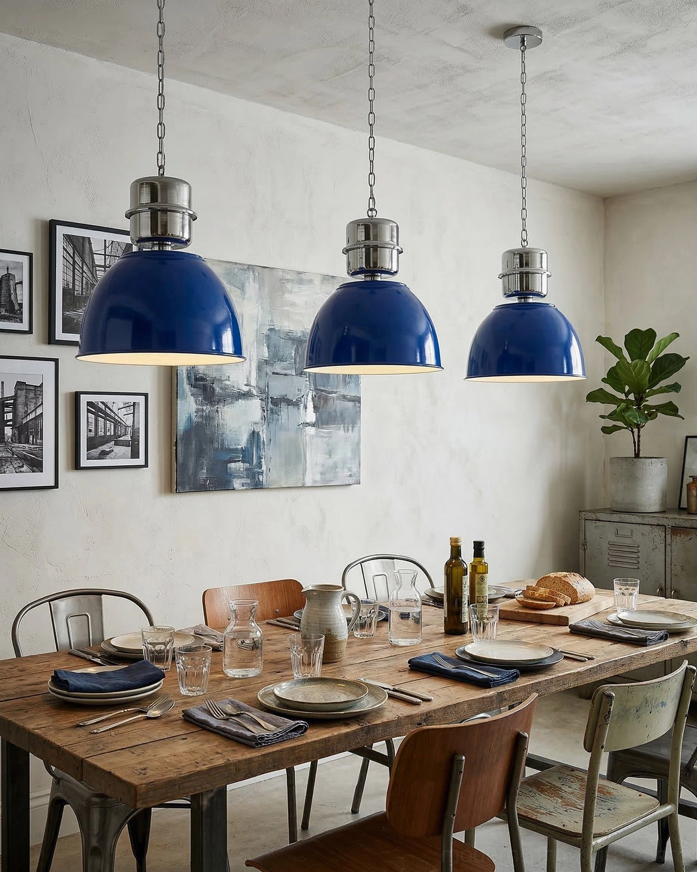 Set of three navy blue Dante pendant lights hanging above rustic wooden dining table with industrial charm
