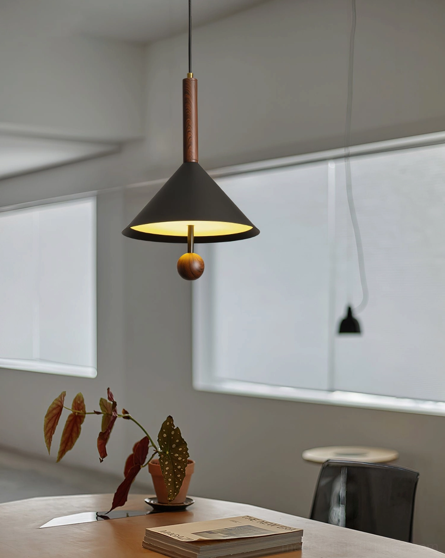 Dante cone pendant light installed above minimalist dining table in warm Scandinavian home setting