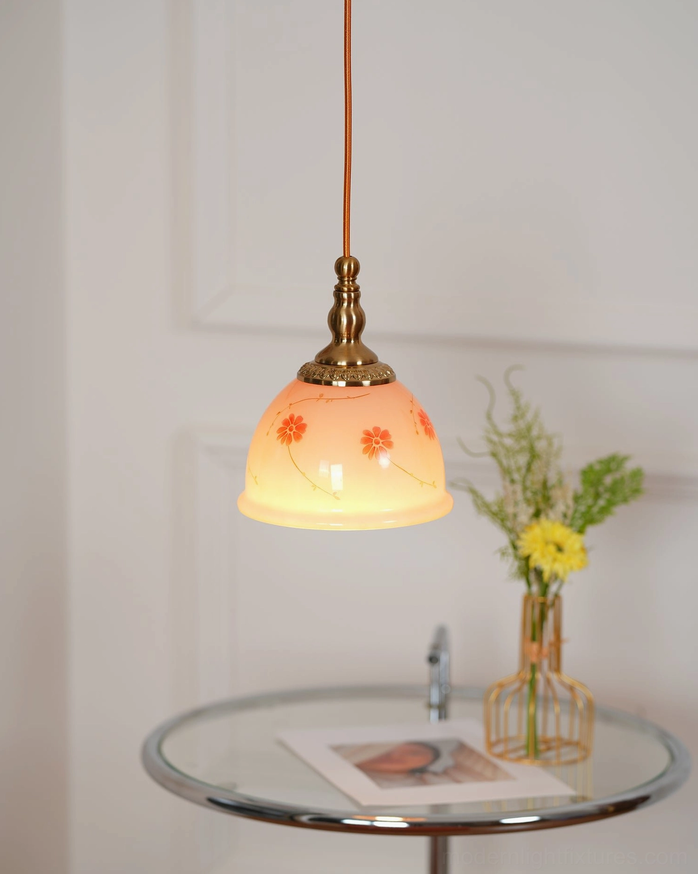 Decorative ceramic floral pendant light installed in home showing warm brass gold fixtures and botanical motifs