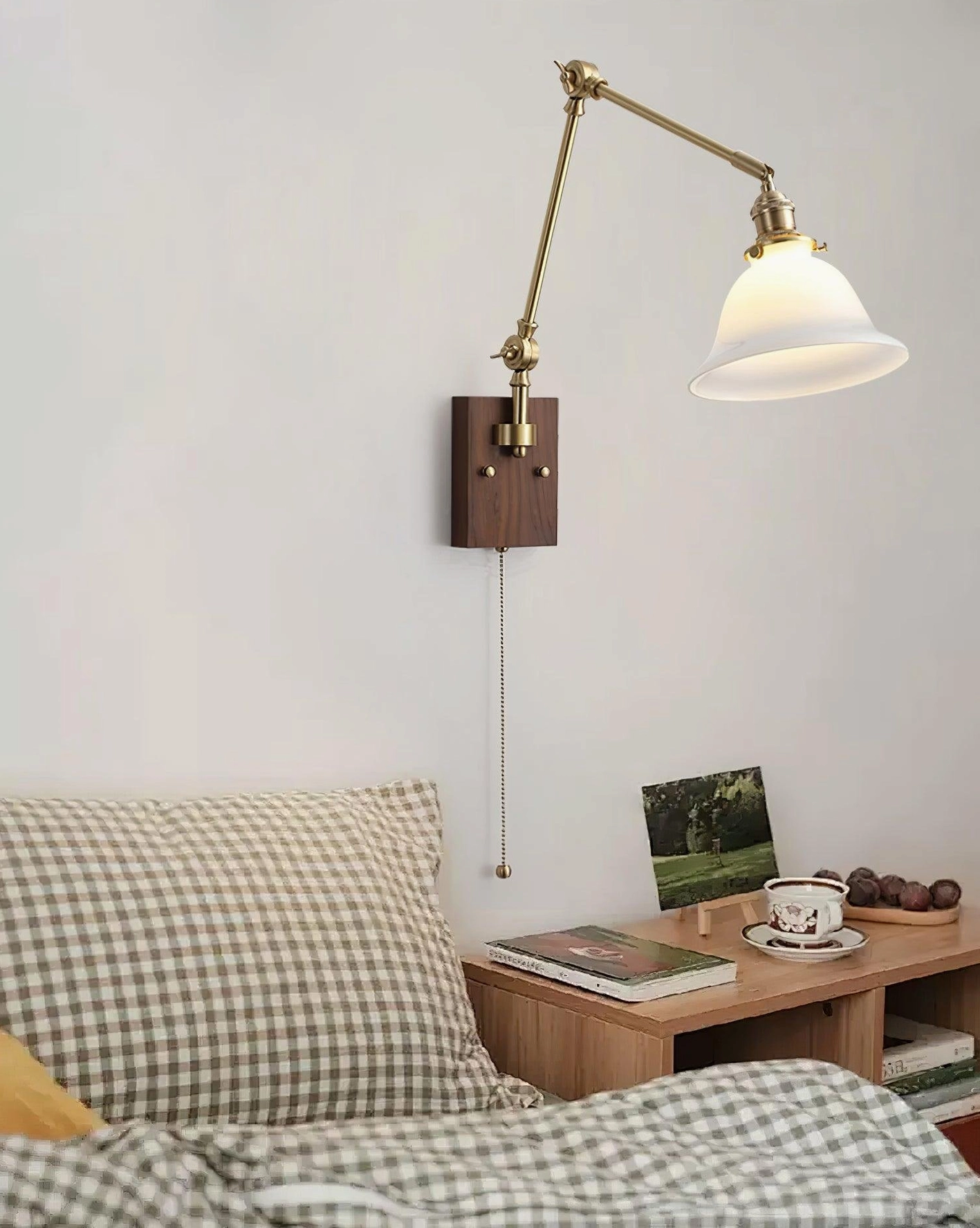 Decorative swing arm wall light with brass body and green glass shade, vintage-inspired pull chain switch and adjustable positioning arm