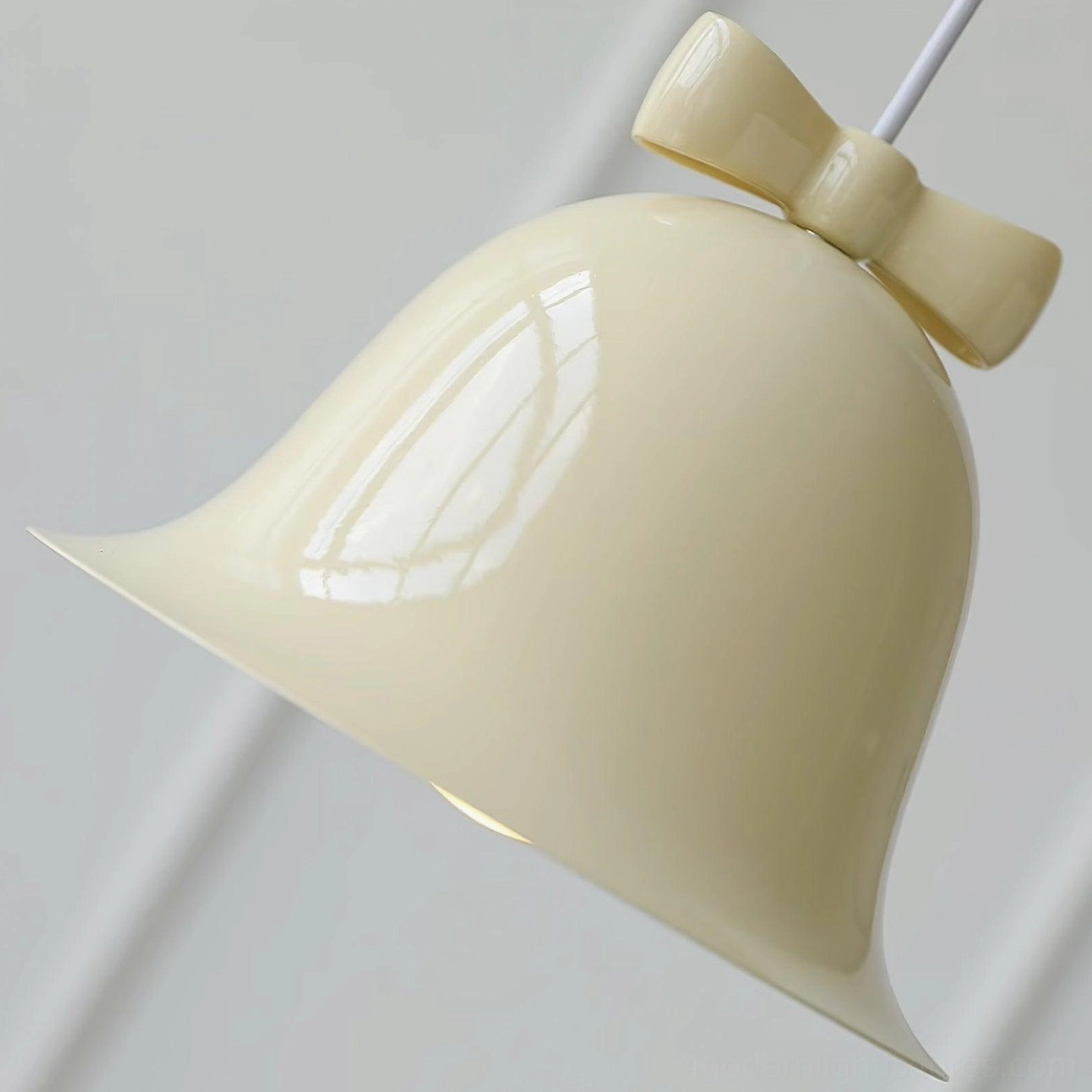 Deep blue ceramic bell pendant lamp with decorative bow in neutral studio background