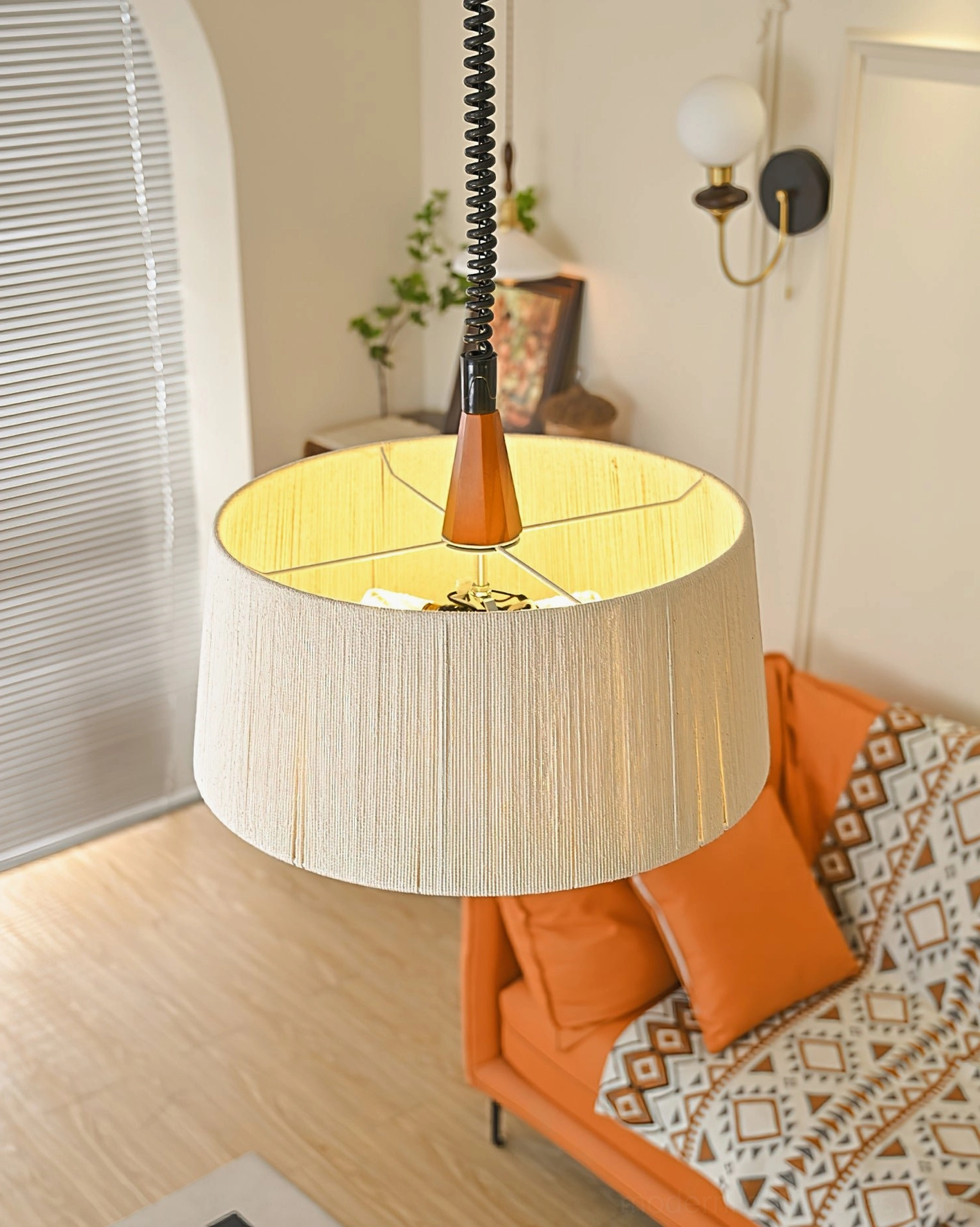 Delaney tapered drum pendant light low-angle view from below, showing warm interior glow and black suspension cord with wood detail