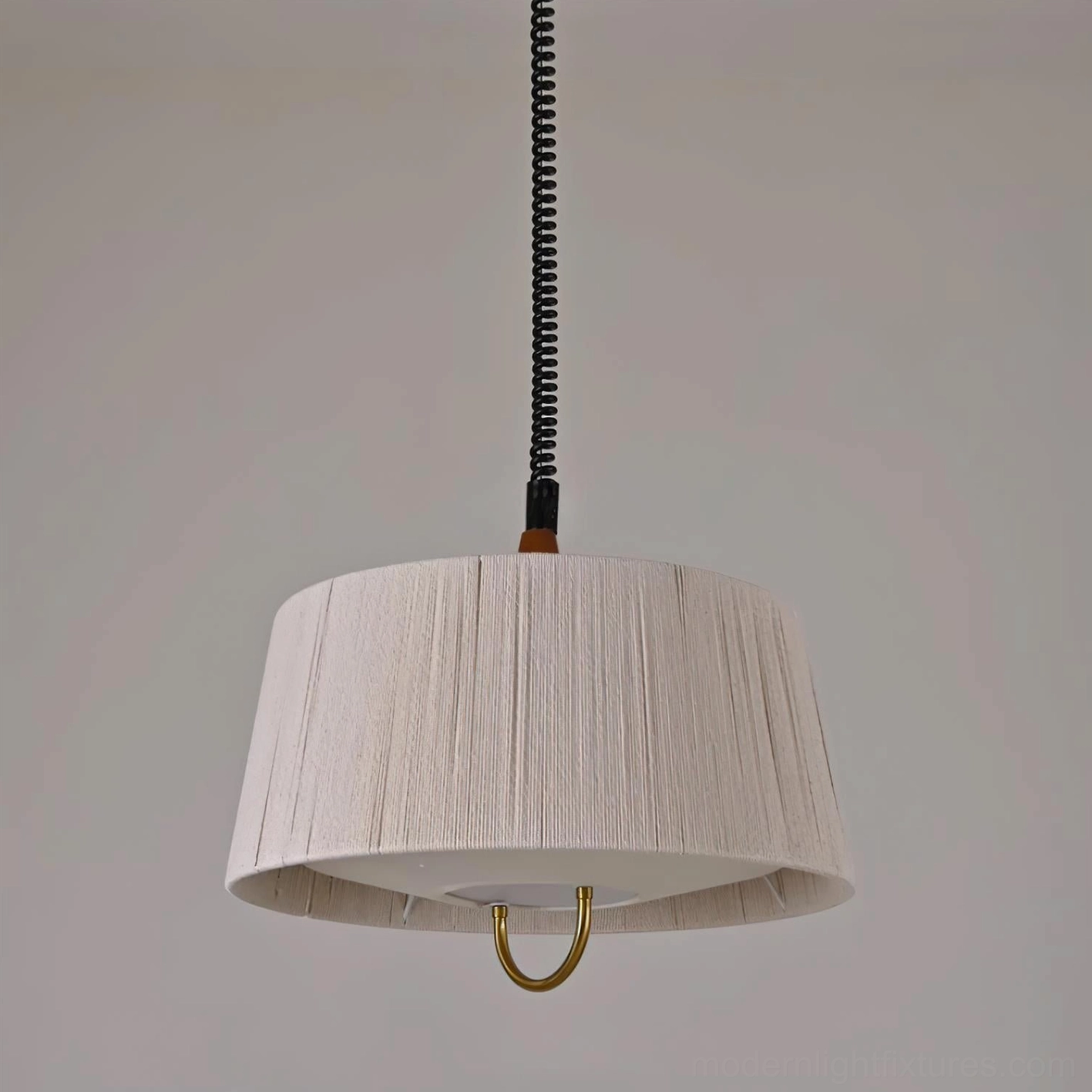 Delaney pendant light showing warm ambient lighting effect and sculptural hemp rope shade profile in neutral studio setting