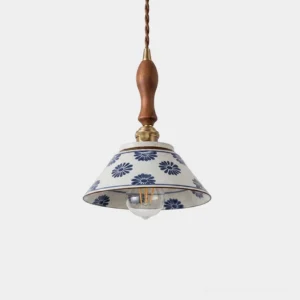 Delfina hand-painted ceramic pendant light with blue floral design and brass wood hardware, front studio view
