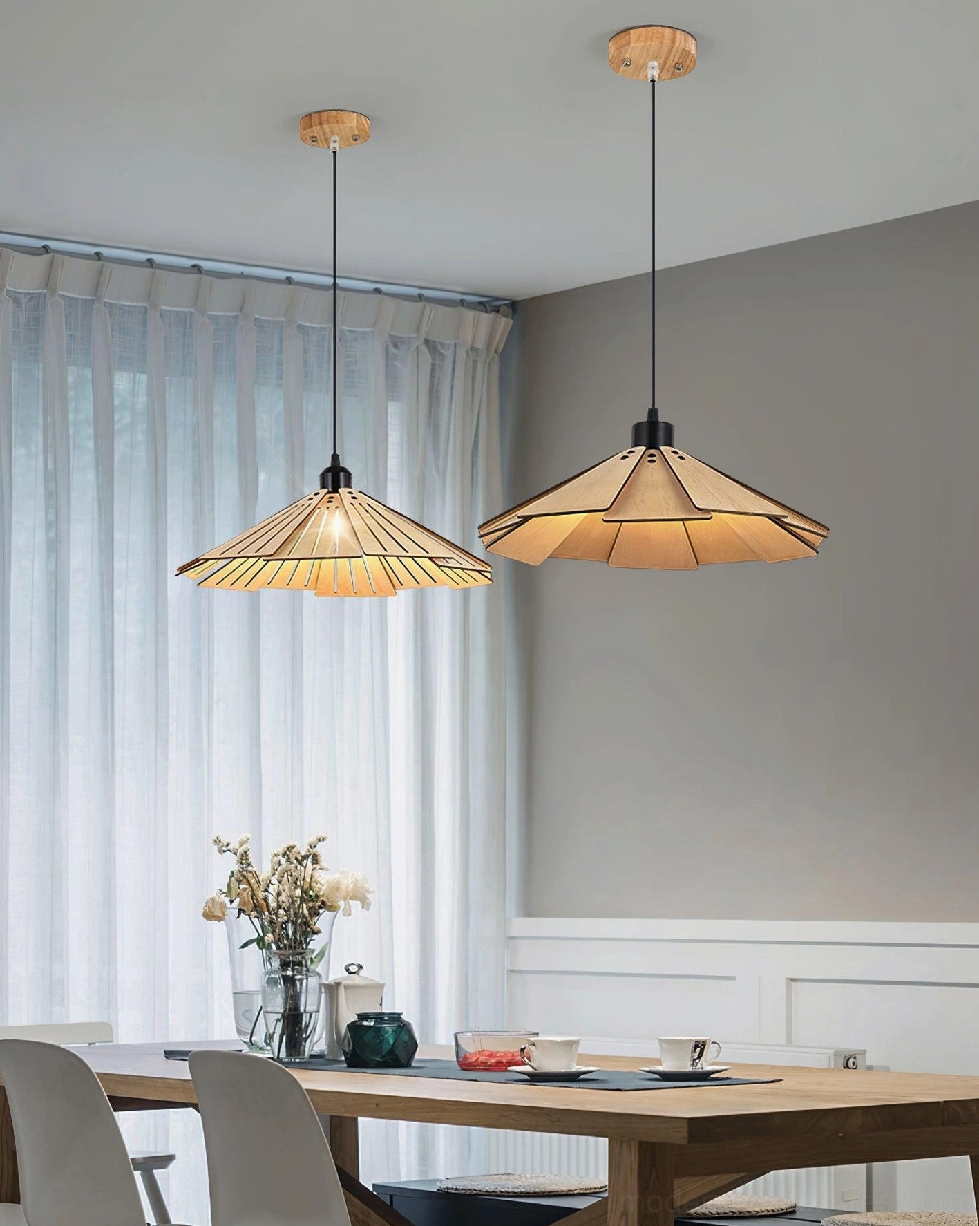 Pair of Delfina wooden pendant lights above dining table in Nordic warm home interior