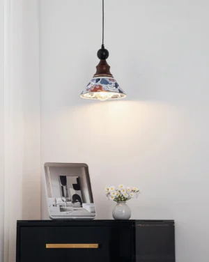 Delft pendant light hanging over bedroom bedside cabinet with warm illumination and decorative props, overhead angle