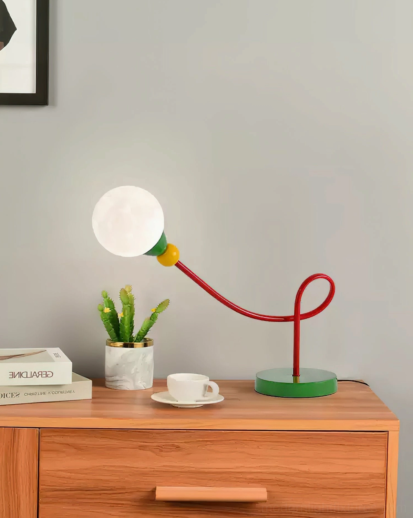Modern sculptural table lamp on dresser with succulent plant and coffee set styling