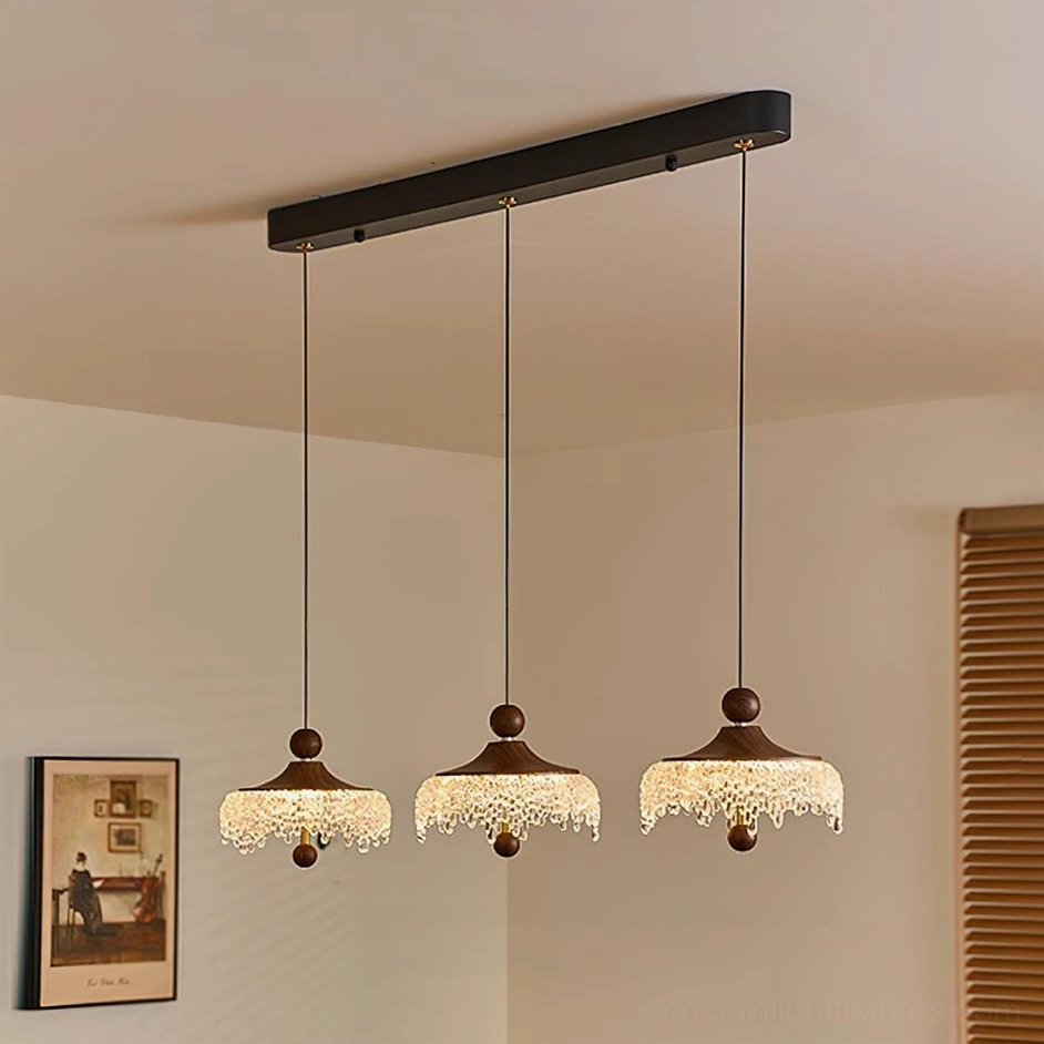 Three Dewdrop Halo pendant lights clustered on black ceiling track, modern residential setting