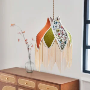 Bohemian fabric pendant lamp with velvet and floral panels in vintage living room setting with wooden cabinet